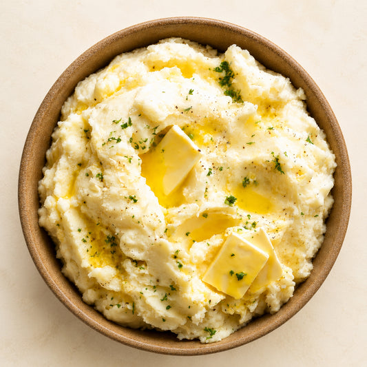 Mashed potatoes with butter in a brown bowl on a beige background